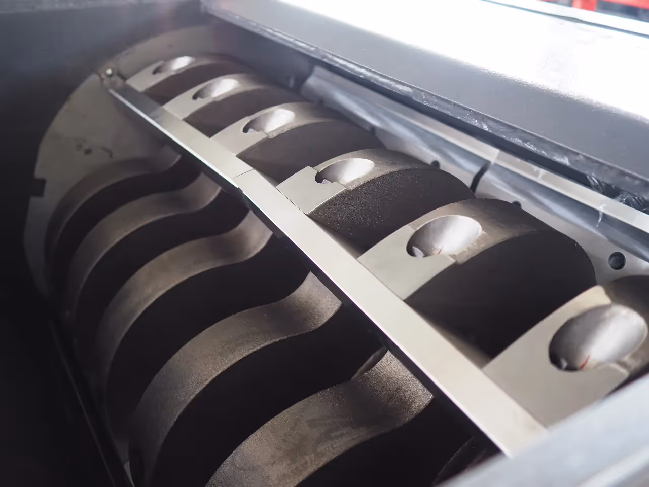 A close-up of the V-type cutting rotor and blades inside a wet plastic granulator, used for efficiently grinding plastic scrap.